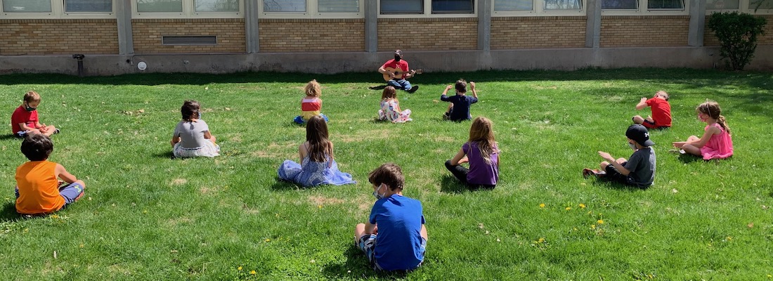 Students outside playing music on sunny day